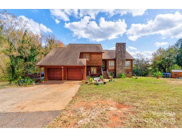 Two-story house with attached garage and stone chimney at 831 College Ave, Shelby, NC 28152