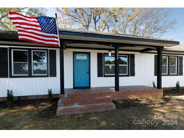 Newly renovated home with white siding, teal door, and brick steps at 1554 Lynwood Dr, Lancaster, SC 29720