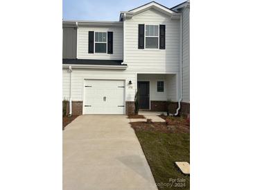 Two-story home with white siding, two-car garage, and landscaping at 1772 Braemar Village Dr, Monroe, NC 28110