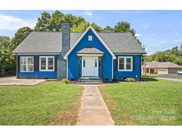 Charming blue house with white accents and manicured lawn at 600 Main St, Stanley, NC 28164