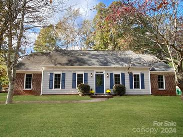 Gray Ranch home with blue shutters, landscaping, and a welcoming front porch at 8444 Knollbrook Dr, Charlotte, NC 28270