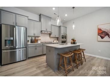 Modern kitchen with gray cabinets and an island at 1186 Lost Cove Rd, Indian Land, SC 29707