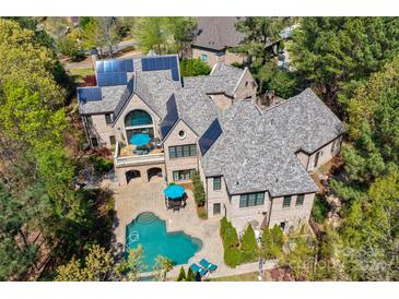 Aerial view of a luxurious home with a pool, expansive backyard, and solar panels at 16908 Ashton Oaks Dr, Charlotte, NC 28278