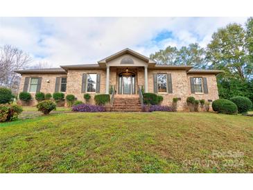 Brick ranch home with landscaping and a large front yard at 101 Hidden Cove Dr, Shelby, NC 28150