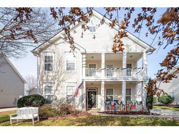 Two-story house with front porch, American flag, and landscaped yard at 18023 Train Station Dr, Cornelius, NC 28031