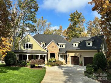 Two-story house with stone accents, a three-car garage, and a large front porch at 20361 Enclave Oaks Ct, Cornelius, NC 28031