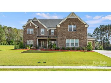 Brick two-story house with landscaped lawn at 709 Cavesson Way, Monroe, NC 28110