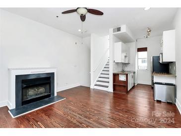 Living room with hardwood floors, fireplace, and open staircase at 2044 Atherton Heights Ln, Charlotte, NC 28203