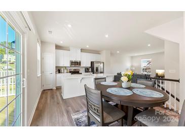 Open concept kitchen and dining area with modern white cabinets and stainless steel appliances at 2016 Tupelo Grove Ln, Gastonia, NC 28054