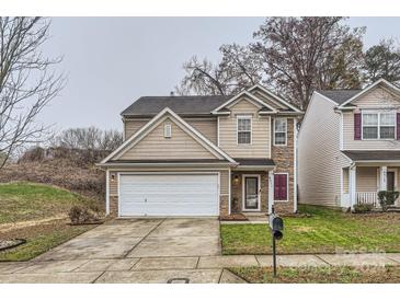 Two-story house with tan siding, stone accents, and a two-car garage at 4511 Belmar Place Rd, Charlotte, NC 28269