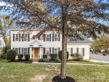 Two-story house with beige siding, dark shutters, and landscaping at 12202 Shiro Ct, Huntersville, NC 28078