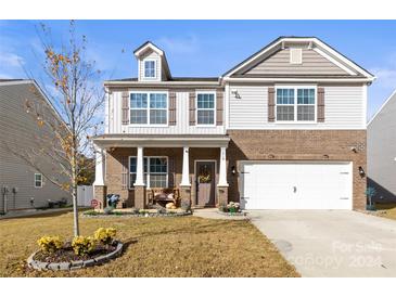 Two story brick home with front porch and landscaped yard at 7019 Branch Fork Rd, Charlotte, NC 28215