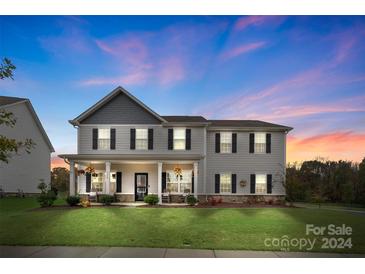 Two-story house with gray siding, a covered porch, and a well-manicured lawn at 3425 Allenby Pl, Monroe, NC 28110