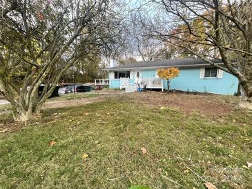 Ranch style home with light blue exterior, deck, and mature trees at 3031 Davidson Hwy, Concord, NC 28027