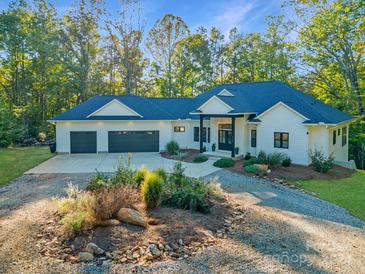 Stunning modern farmhouse exterior with a two-car garage and landscaped grounds at 1524 Moss Creek Ln, Iron Station, NC 28080