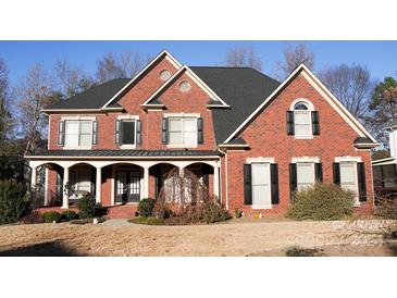 Brick two-story house with a covered porch and landscaping at 2409 Arden Gate Ln, Charlotte, NC 28262