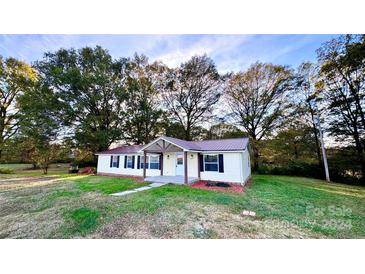 Ranch home with metal roof, landscaping, and covered porch at 6706 Wolf Pond Rd, Monroe, NC 28112