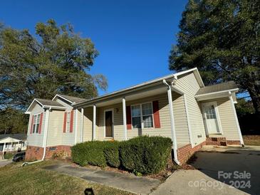 Tan one-story house with red shutters, covered porch, and manicured landscaping at 203 Carwen Ct, Kannapolis, NC 28081