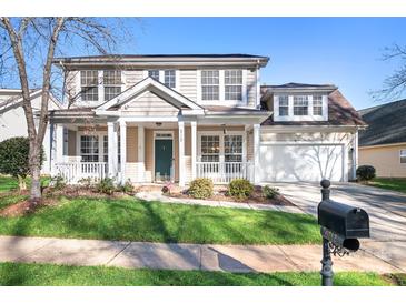 Two-story house with beige siding, a porch, and a two-car garage at 6712 Colonial Garden Dr, Huntersville, NC 28078