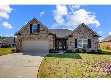 Brick ranch home with a two-car garage and landscaped lawn at 4403 Gwen Hartis Ct, Monroe, NC 28110