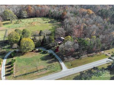 Aerial view of a rustic home on a large lot with mature trees and a long driveway at 5407 Davis Rd, Waxhaw, NC 28173