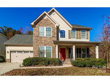 Two-story house with stone and siding, two-car garage, and landscaped yard at 13104 Serenity St, Huntersville, NC 28078