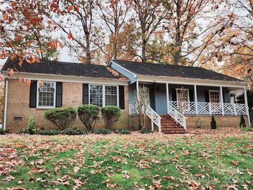 Brick ranch house with covered porch and mature trees at 725 Brookside Dr, Gastonia, NC 28056