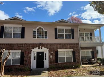 Two-story condo building with brick and siding, featuring a balcony and ample windows at 19744 Feriba Pl, Cornelius, NC 28031