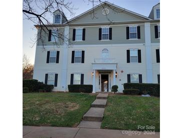 Three-story building exterior with landscaping and walkway at 1174 Plaza Walk Dr, Charlotte, NC 28215