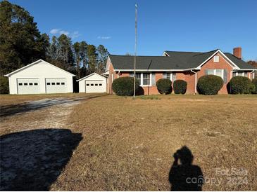 Brick ranch house with attached garage and spacious yard at 6989 Kershaw Camden Hwy, Kershaw, SC 29067