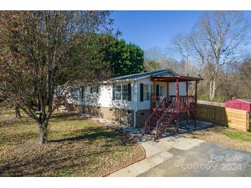 Single-wide mobile home with covered porch and landscaped yard at 3352 Bendwood Rd, Newton, NC 28658