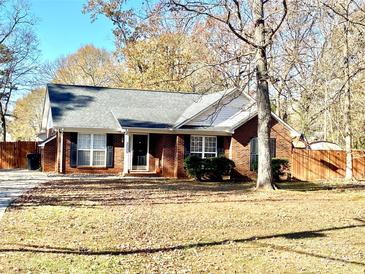 Brick ranch house with a landscaped yard and wooden fence at 2005 Wilson Ave, Monroe, NC 28110