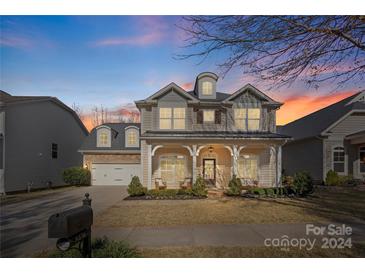 Two-story house with beige siding, a covered porch, and a two-car garage at 8436 Whitehawk Hill Rd, Waxhaw, NC 28173