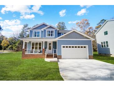 Two-story house with blue siding, white garage door, and brick accents at 2410 Forrestbrook Dr, Kannapolis, NC 28083