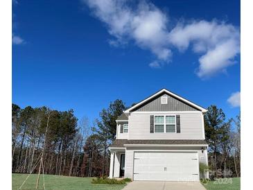 Two-story house with gray and white siding, a white garage door, and a well-maintained lawn at 659 Lamorak Pl, Richburg, SC 29729