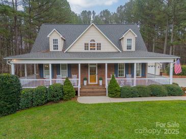 Two-story home features a front porch, landscaped yard, and brick facade at 6998 Ridgeway Rd, Stanley, NC 28164