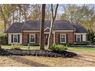 Brick ranch house with mature landscaping and a spacious lawn at 9406 Hinson Dr, Matthews, NC 28105