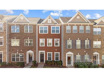 Three-story brick townhouses with front yards at 7111 Brighton Park Dr, Mint Hill, NC 28227