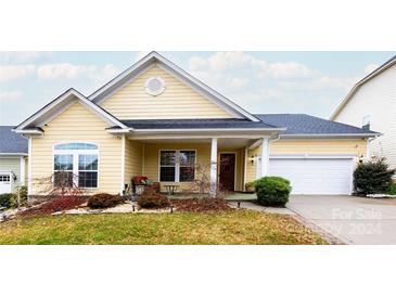 Beautiful yellow house with a two-car garage and well-manicured lawn at 11538 Warfield Ave, Huntersville, NC 28078