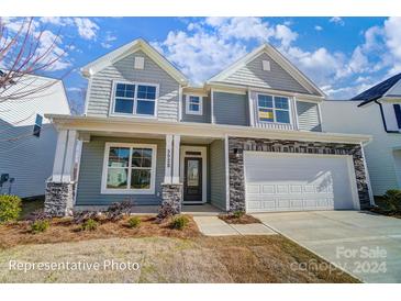 Two-story house with gray siding, stone accents, and a two-car garage at 5103 Heathland Dr # 50, Charlotte, NC 28215