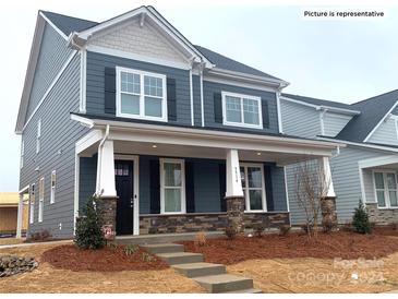 Two-story home with gray siding, stone accents, and a front porch at 9601 Pointer Rd # 77, Huntersville, NC 28078