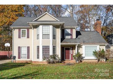 Two-story house with gray roof, beige siding, and maroon accents at 2027 Killarney Pl, Charlotte, NC 28262