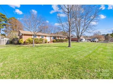 Ranch style brick home with a spacious lawn and detached garage at 1904 Falconhurst Dr, Charlotte, NC 28216