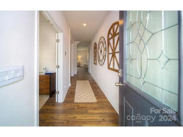 Bright hallway with wood floors and decorative wall accents at 3064 Sassafras Trl, Gastonia, NC 28056