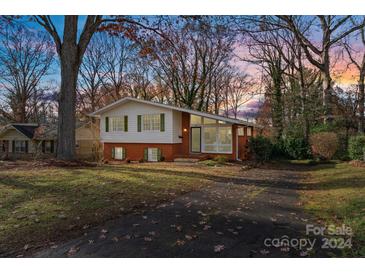 Brick ranch home with a landscaped yard and attached carport at 6108 Netherwood Dr, Charlotte, NC 28210