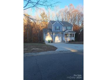 Two-story house with gray siding, two-car garage, and a front porch at 7300 Rothmore St, Charlotte, NC 28215