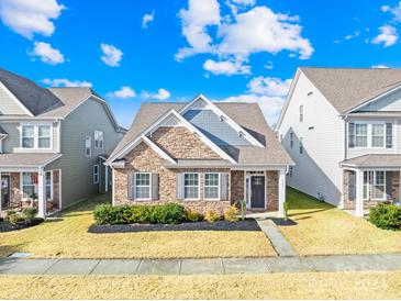 Charming two-story home with a stone and siding exterior and a front yard at 8142 Kalson St, Huntersville, NC 28078