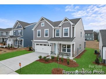 Two-story home with gray siding, stone accents, and a landscaped lawn at 121 Stonewater Dr # 21, Red Cross, NC 28129