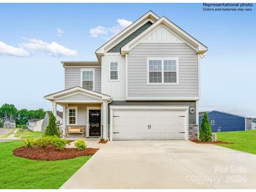 Two-story house with gray siding, two-car garage, and landscaped front yard at 15147 Windy Plains Rd, Charlotte, NC 28262