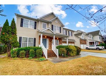 Two-story house with tan siding, stone accents, and a landscaped lawn at 417 Stowe Rd, Belmont, NC 28012